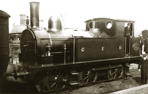 E22 no. 151 at Braintree during the period 1889-1894 in 'as built' condition with separate handrails, without the Macallen blastpipe, no coal rails on the bunker and running as a 2-4-0T with the front coupling rods removed. Photograph ©Public Domain.